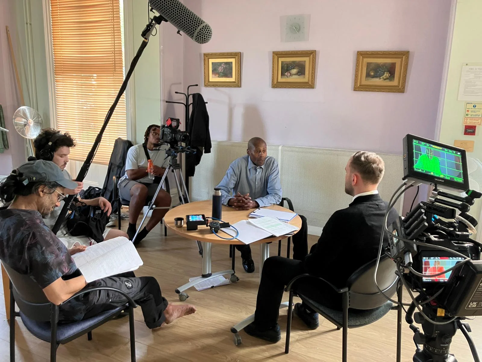A production where people are giving an interview around a round table.
